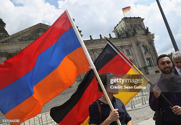 Activists hold up Armenian and German flags outside the Reichstag after parliamentarians at the Bundestag approved a resolution to recognize the 1915...