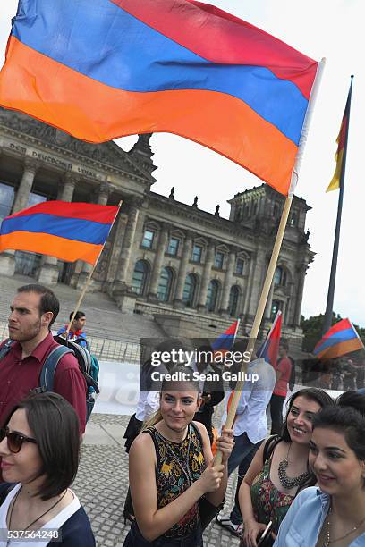Activists hold up Armenian flags outside the Reichstag after parliamentarians at the Bundestag approved a resolution to recognize the 1915 Armenian...