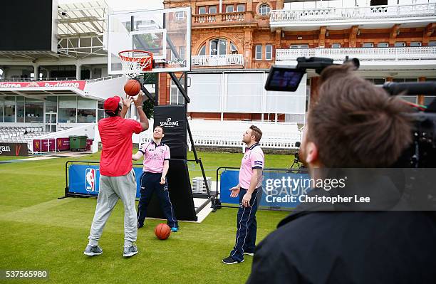 Player, Andre Drummond shows his basketball skills to Middlesex Cricketers Eoin Morgan of England and Brendan McCullum of New Zealand at Lords on...