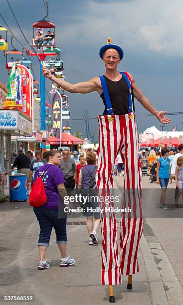 Carnival worker walks the midway on stilts at the Ohio State Fair