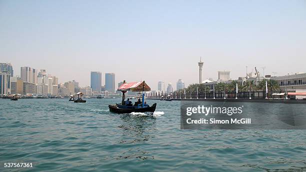 Abras travel across Dubai Creek to transport passengers between Bur Dubai and Deira in Dubai, United Arab Emirates