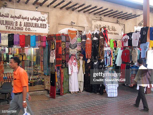 Clothing and footwear displays outside shops in Al Souk Al Kabir , Bur Dubai, Dubai, United Arab Emirates