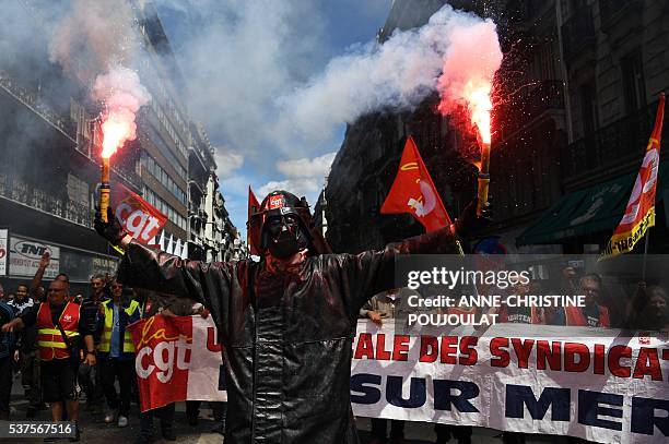 Man wearing a Dark Vador mask holds smoke flares during a demonstration against the French government's planned labour law reforms, on June 2, 2016...