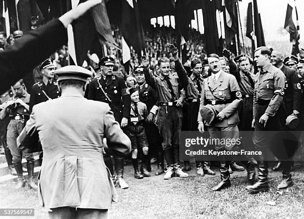 Chancellor Adolf Hitler, Baldur von Schiracht, hitlerian youth's chief, and doctor Wilhelm Frick, Reich's minister, attend the 80 000 young nazis'...