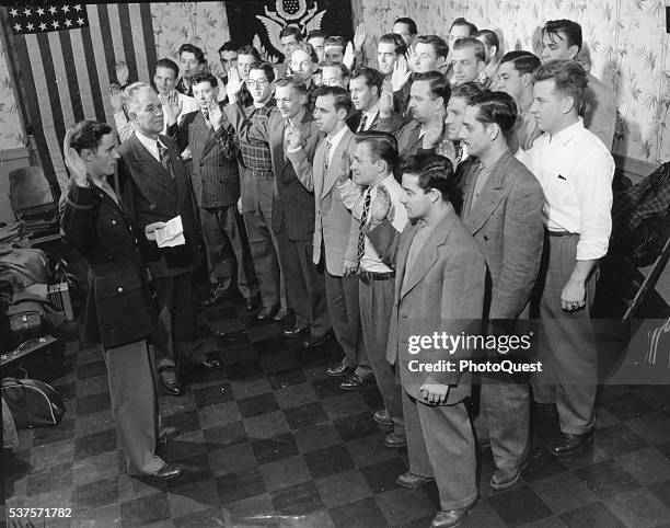 Elevated view of a group of men aged 23 to 25 as they take the oath of enlistment, Chicago, November 29, 1946. This group was among the first to be...