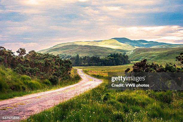 road winding across moorland, isle of jura - argyle stock pictures, royalty-free photos & images