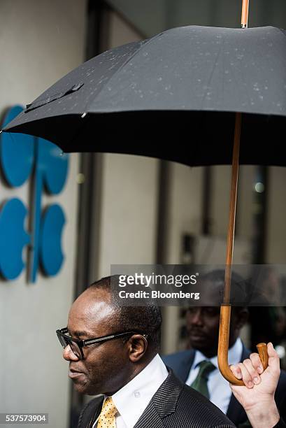 Emmanuel Ibe Kachikwu, Nigeria's petroleum and resources minister, shelters under an umbrella as he departs the 169th Organization of Petroleum...