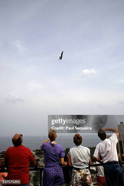 Group of people watch as a jet performs a steep climb above Lake Michigan as part of the Chicago Air and Water Show, Chicago, Illinois, 1980s.