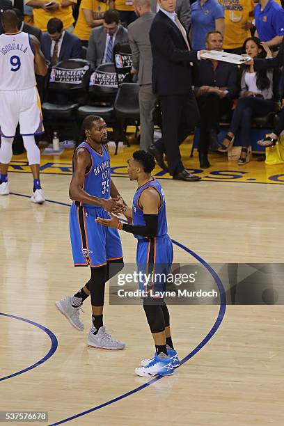 Russell Westbrook and Kevin Durant of the Oklahoma City Thunder shake hands in Game Five of the Western Conference Finals against the Golden State...