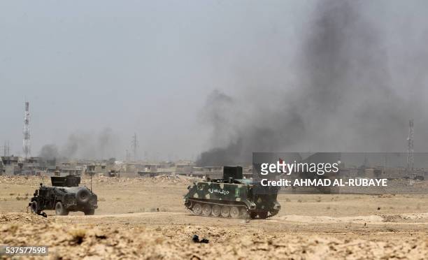 Iraqi government forces military vehicles are stationed on the road as they engage in combat with the support of the Popular Mobilisation units in...