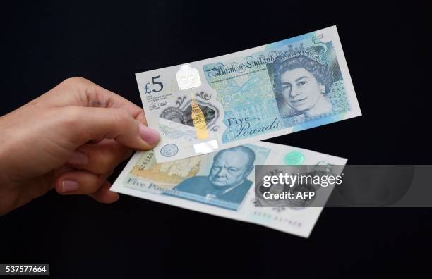 Woman looks at a new £5 banknote bearing the image of wartime leader Winston Churchill at its unveiling by the Bank of England at Blenheim Palace in...