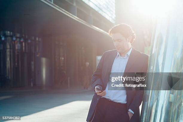 geschäftsmann eingabe auf seinem smartphone, gibt es im modernen spalte - entsättigt stock-fotos und bilder