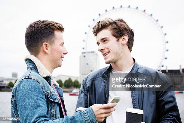 young british man asking friend social networking advice - only young men stock pictures, royalty-free photos & images