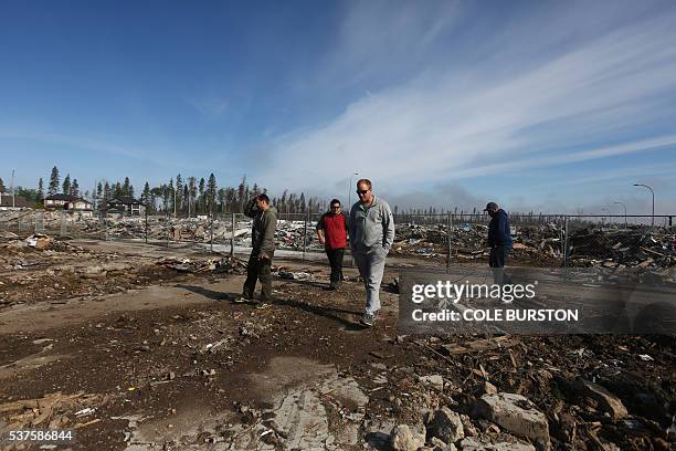 Residents walk through and survey the devastated neighbourhood of Timberlea in Fort McMurray, Alberta on June 2, 2016. Some neighbourhoods of Fort...