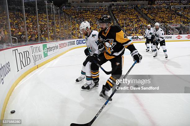 Nick Spaling of the San Jose Sharks and Justin Schultz of the Pittsburgh Penguins skate toward the end boards for the puck during Game One of the...