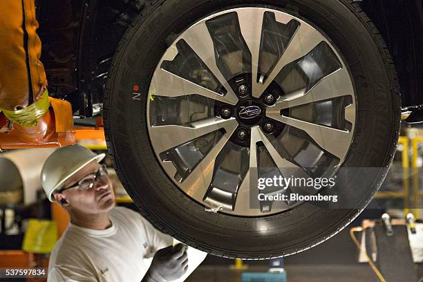 Subaru Assembly Line An employee looks at a tire on the assembly line at the Subaru of ...