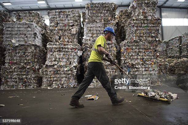 An employee sweeps paper off the floor in the shipping area at the Rumpke Recycling Center in Cincinnati, Ohio, U. S., on Tuesday, May 10, 2016....