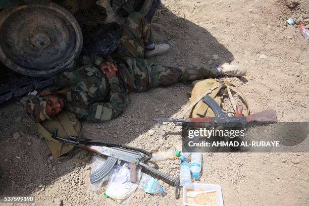 Member of the Iraqi government forces rests in the shade of a vehicle in the Saqlawiyah area, north west of Fallujah, during an operation to regain...