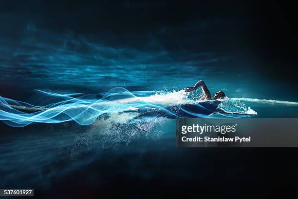 man swimming crawl, leaving streaks of light - man splashed with colour fotografías e imágenes de stock