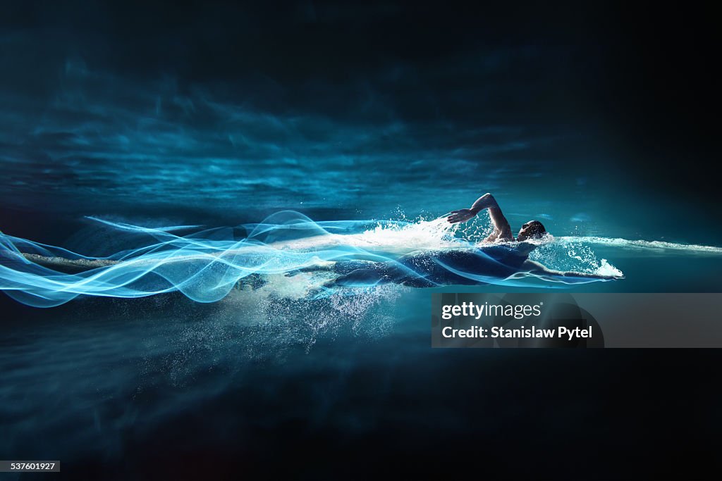 Man swimming crawl, leaving streaks of light