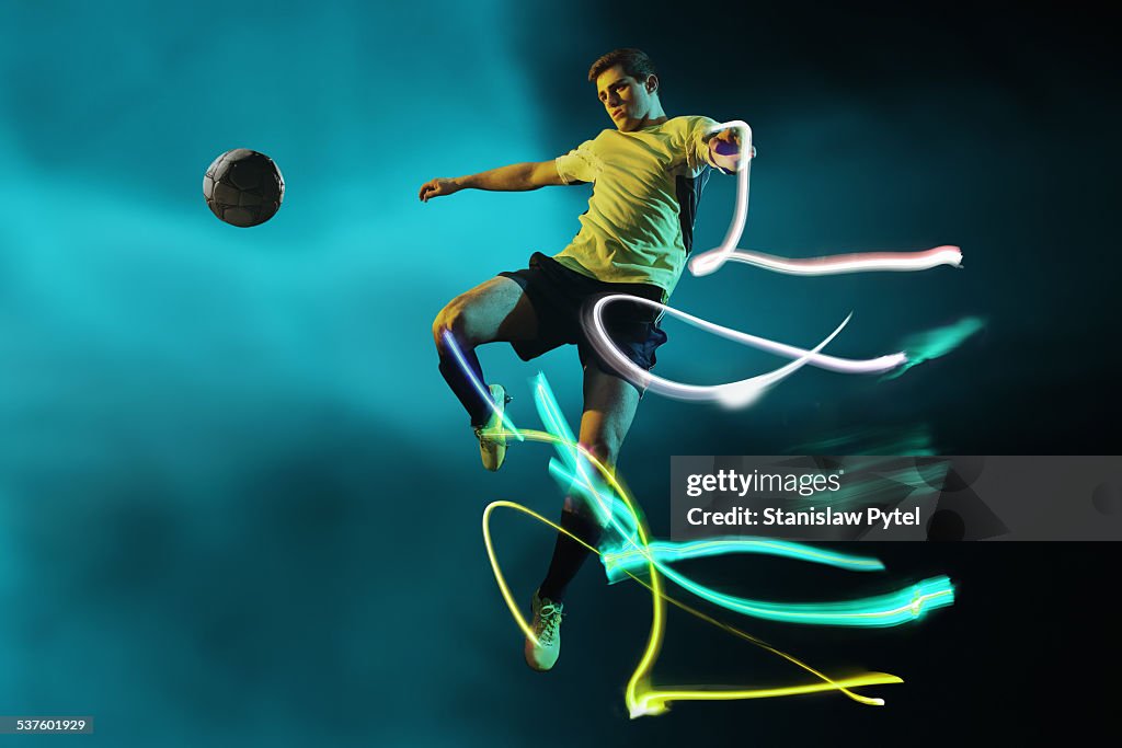 Soccer player kicking ball,  streaks of light