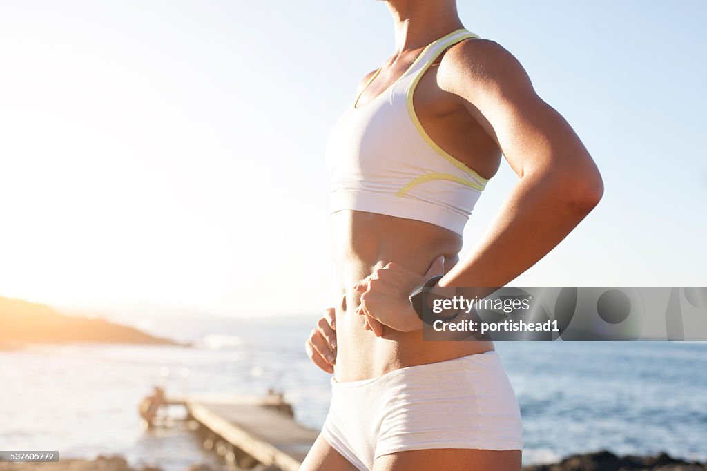 Side view of sportswoman standing at beach