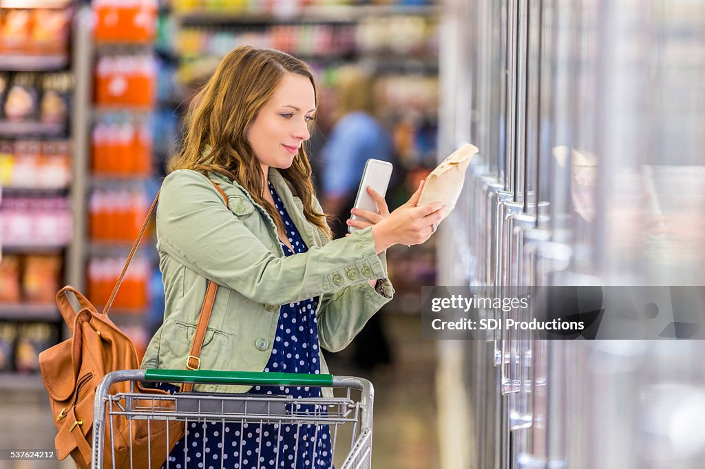 Woman using phone at grocery store