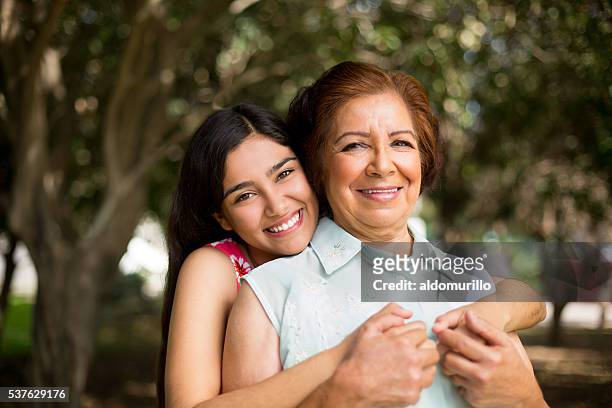 granddaughter holding her grandmother tight - granddaughter stock pictures, royalty-free photos & images
