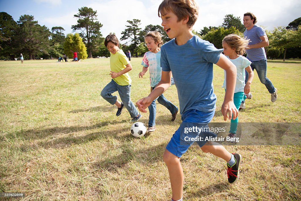 Children playing soccer in park