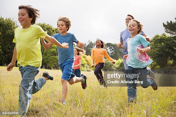 children running in park - running boy stock pictures, royalty-free photos & images