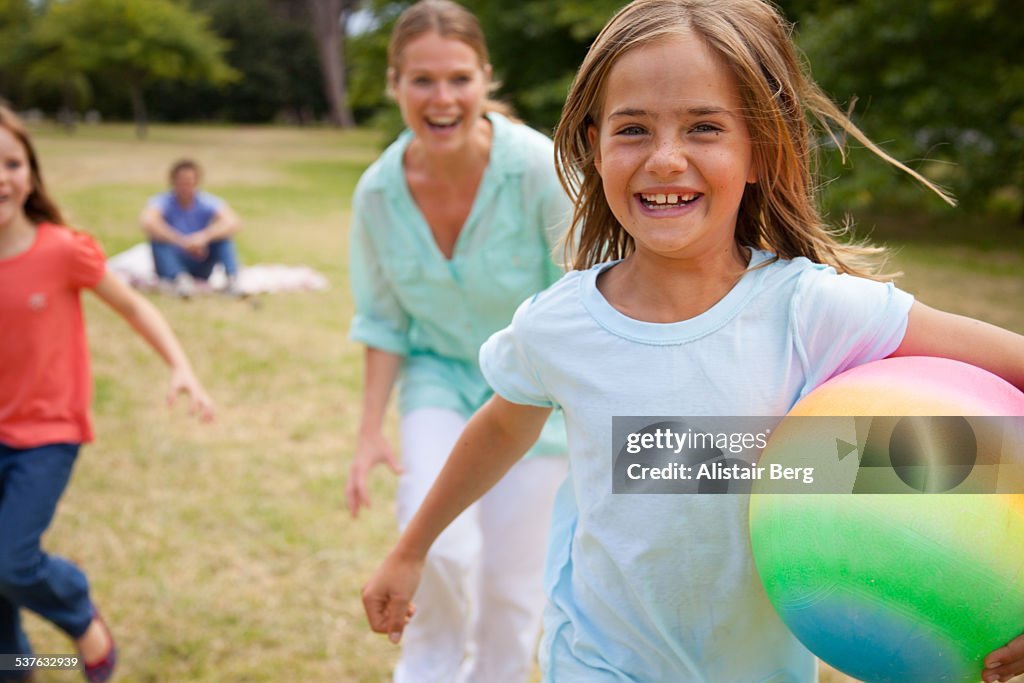 Girls running in park with their mother