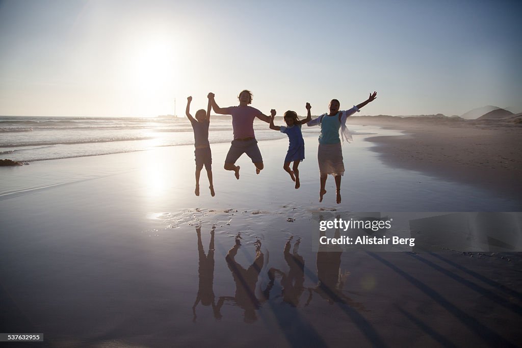 Family jumping together on a beach