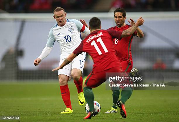 Wayne Rooney of England takes on Joao Moutinho and Vieirinha of Portugal during the International Friendly match between England and Portugal at...