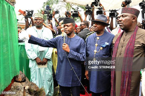 Vice-president Yemi Osinbajo unveils a commemorative plaque to launch the clean up of Ogoniland, accompanied by Rivers State Governor Nyesom Wike and...