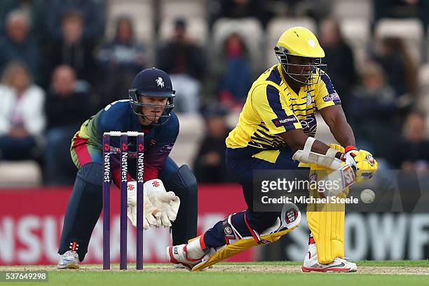 Michael Carberry of Hampshire reverse sweeps as wicketkeeper Sam Billings of Kent looks on during the NatWest T20 Blast match between Hampshire and...