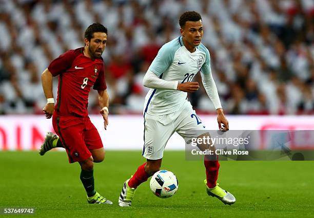 Dele Alli of England is chased by Joao Moutinho of Portugal during the international friendly match between England and Portugal at Wembley Stadium...