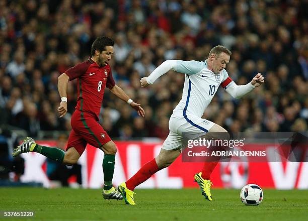 England's striker Wayne Rooney runs past Portugal's midfielder Joao Moutinho during the friendly football match between England and Portugal at...