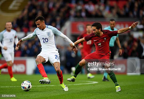 Dele Alli of England holds off Joao Moutinho of Portugal during the international friendly match between England and Portugal at Wembley Stadium on...