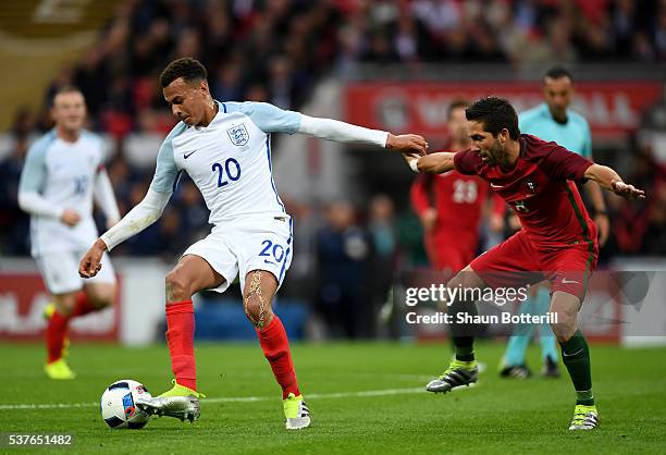 Dele Alli of England holds off Joao Moutinho of Portugal during the international friendly match between England and Portugal at Wembley Stadium on...