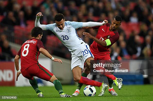 Dele Alli of England takes on Joao Moutinho and Nani of Portugal during the international friendly match between England and Portugal at Wembley...