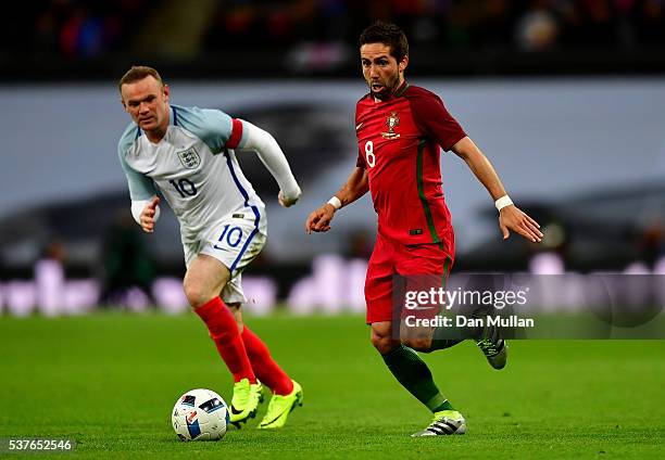 Joao Moutinho of Portugal is chased by Wayne Rooney of England during the international friendly match between England and Portugal at Wembley...