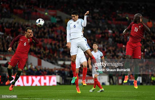 Chris Smalling of England beats Ricardo Carvalho and Danilo Pereira of Portugal as he scores their first goal during the international friendly match...