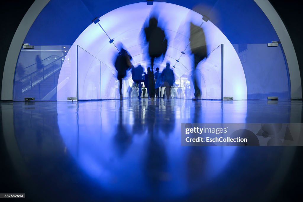 People passing LED illuminated tunnel