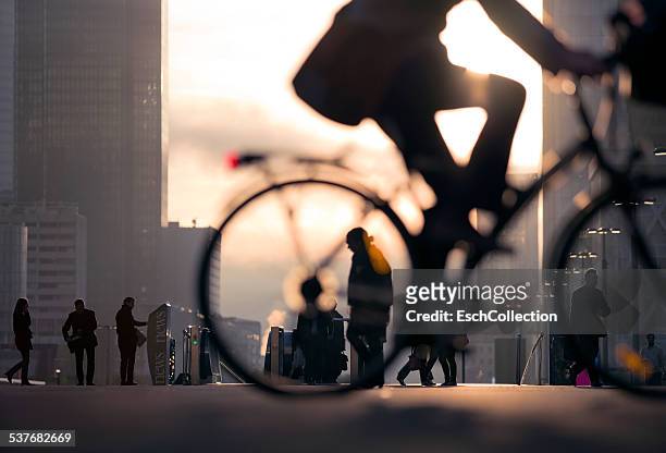 businessman on bicycle passing skyline la defense - selective focus stock-fotos und bilder