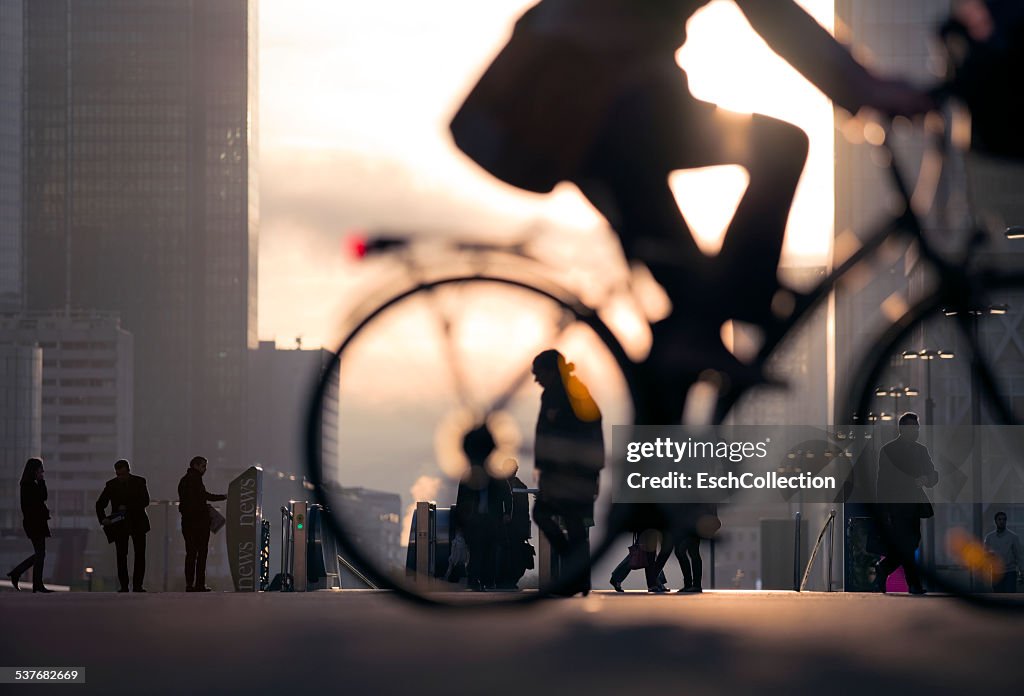 Businessman on bicycle passing skyline La Defense