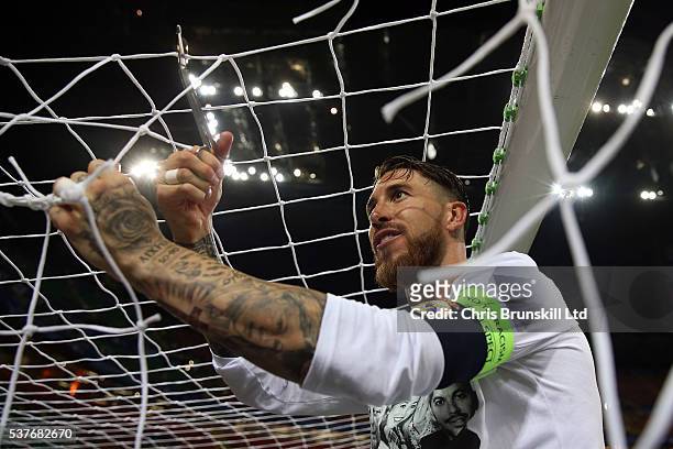 Sergio Ramos of Real Madrid cuts the goal netting following the UEFA Champions League Final between Real Madrid and Club Atletico de Madrid at Stadio...
