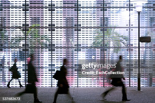 Business people passing modern office building Business people passing modern office building