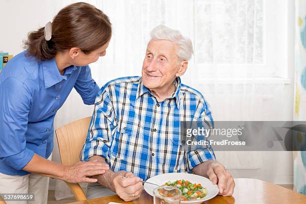 fürsorgliche mit alter mann hilft, essen - senior essen stock-fotos und bilder
