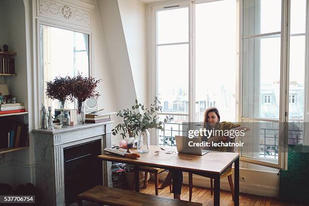 jeune travailleur indépendant femme se détendant dans son appartement parisien - femme fenêtre photos et images de collection