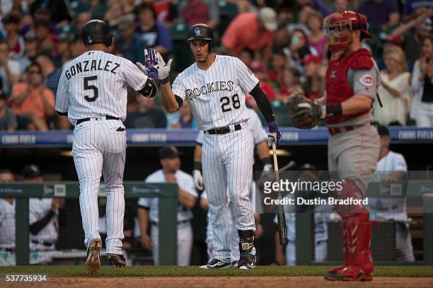 Carlos Gonzalez of the Colorado Rockies celebrates with Nolan Arenado after hitting a fourth inning solo homerun off of Alfredo Simon of the...